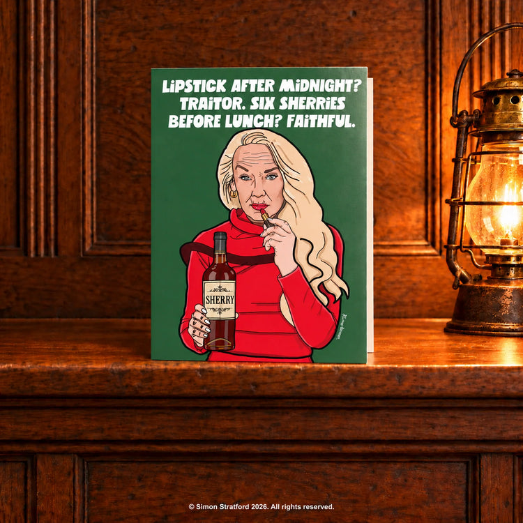 Jerry Hall Christmas card holding sherry and lipstick: Lipstick after midnight? Traitor. Six sherries before lunch? Faithful. Standing slightly open on a wooden mantelpiece beside a glowing antique lamp.