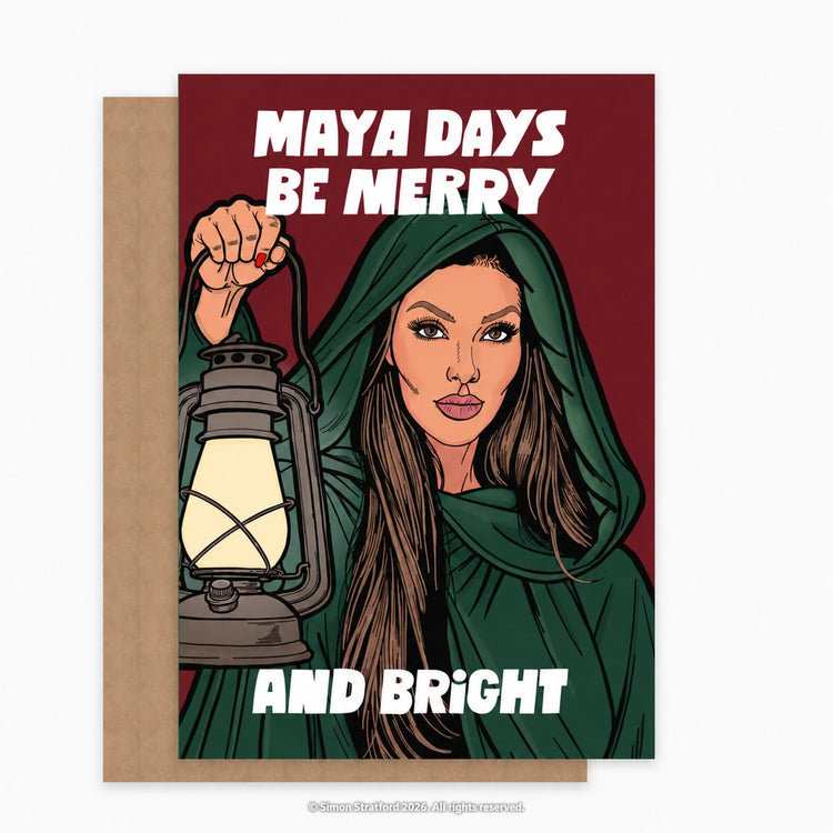 Maya Jama Christmas card showing her in a green cloak holding a lantern: Maya days be merry and bright. Shown with a brown kraft envelope peeking out to the left on a light grey background.