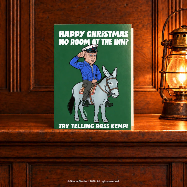 Ross Kemp Christmas card showing him saluting on a donkey: No room at the inn? Try telling Ross Kemp. Standing slightly open on a wooden mantelpiece beside a glowing antique lamp.